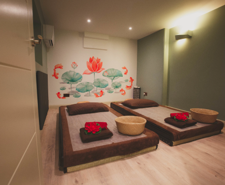 An image of the traditional Thai massage room at Asiatic Thai Massage, featuring a Thai massage bed and lotus flower wallpaper.
