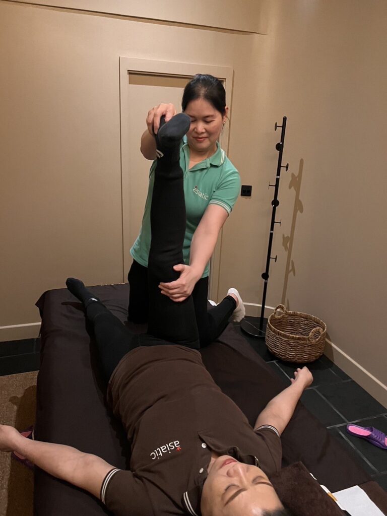 Image of massage therapist performing a hamstring stretch, promoting the best Thai Massage London