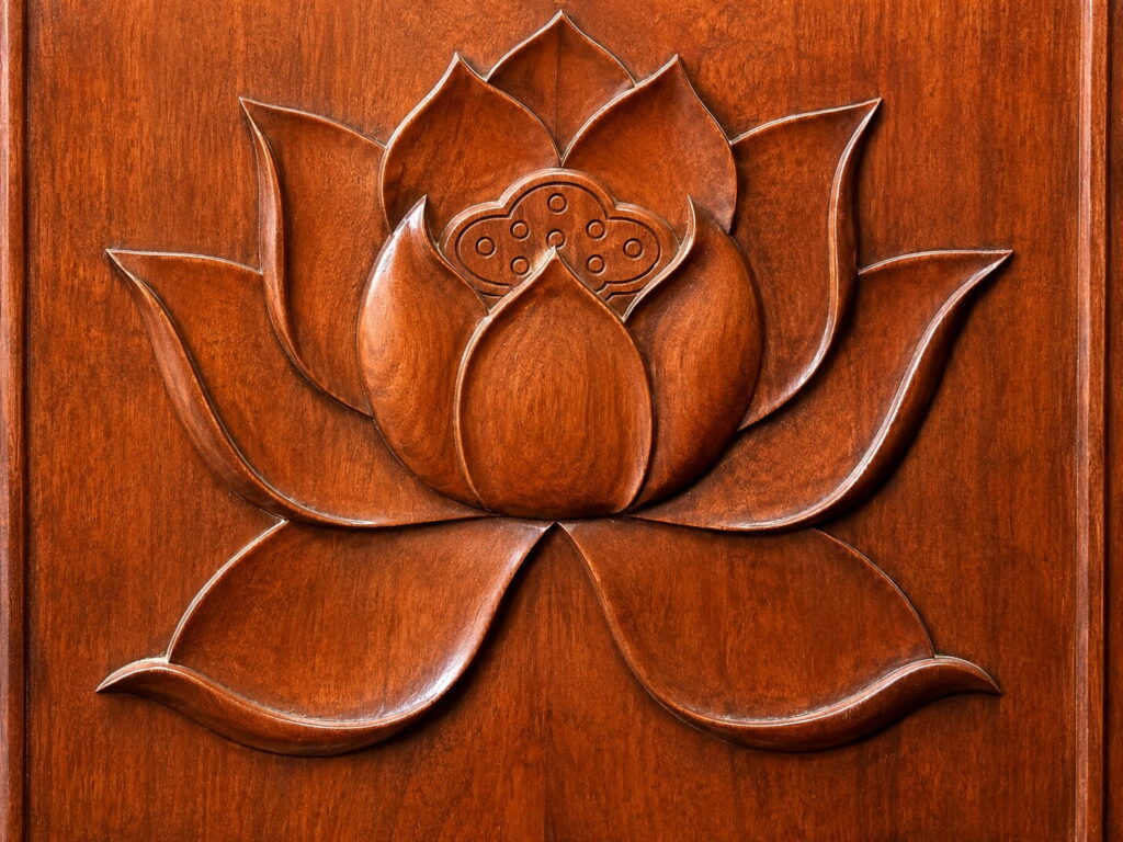 Lotus flower carved into an ancient wooden temple door in Shanghai reflecting spiritual symbolism and Eastern wellness traditions.