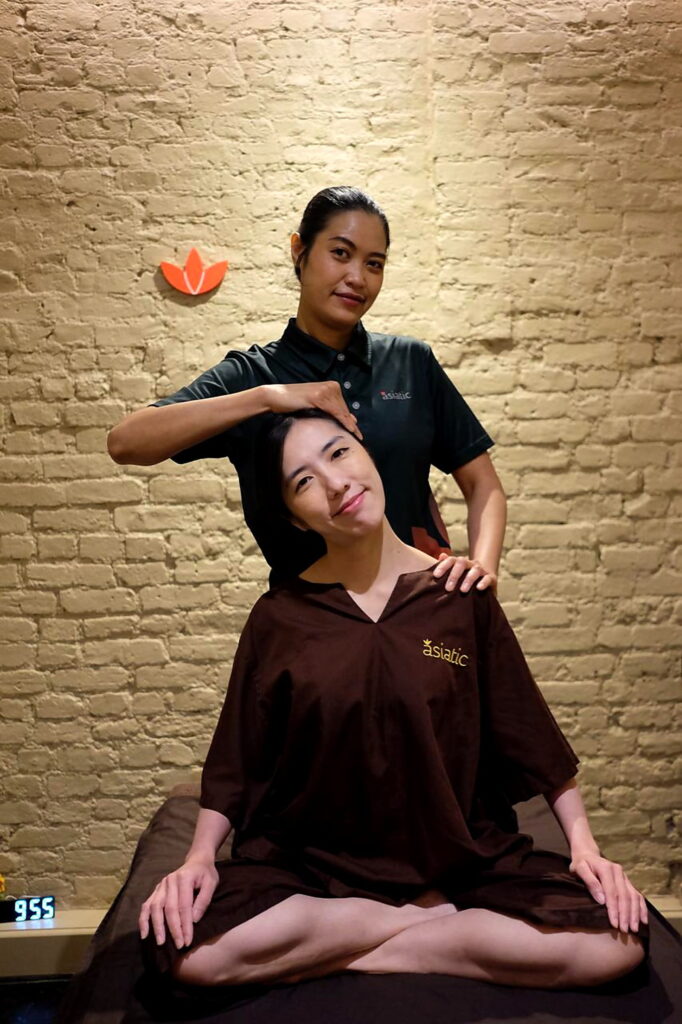 Asiatic therapist providing Thai massage bodywork in a warm Upper Street studio in Highbury & Islington