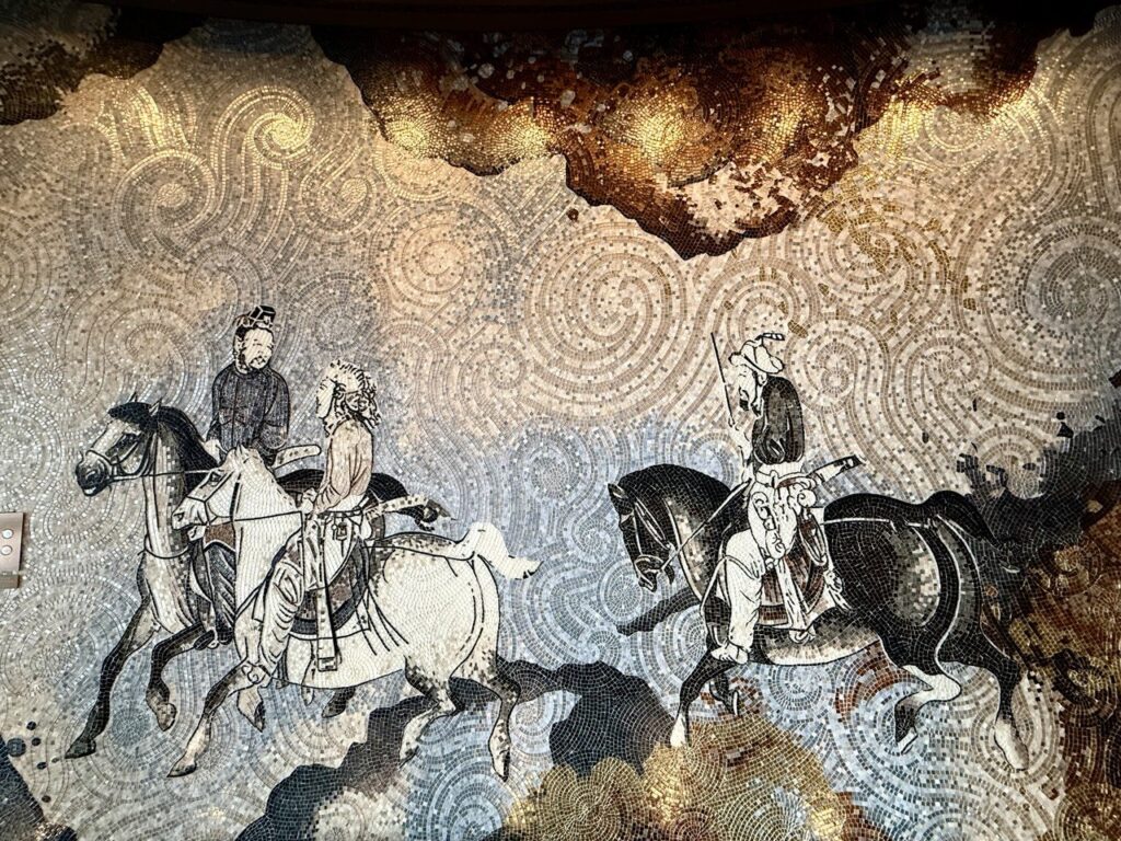 A 10-metre mosaic of three horsemen captured at the Shanghai Tower, representing the indestructible structural integrity and 17-year legacy of Asiatic Thai Massage in Angel, London.