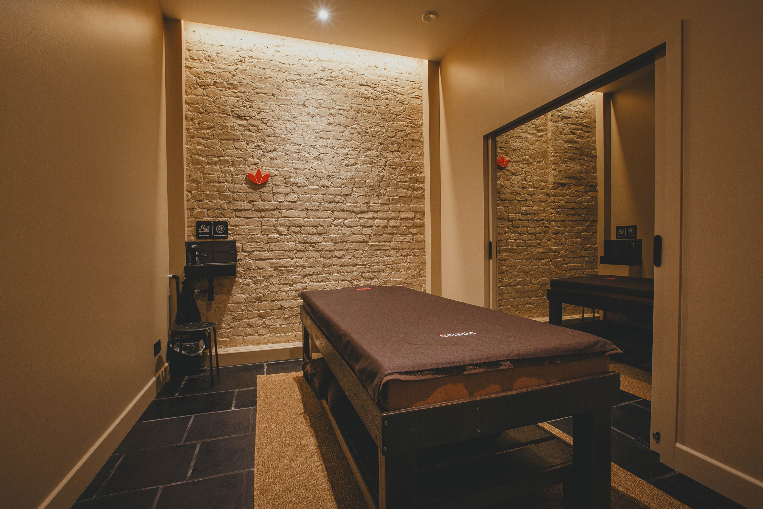 Architectural minimalist couple massage suite at Asiatic 262 Upper Street featuring custom-engineered sliding pocket doors by Rellish UK.