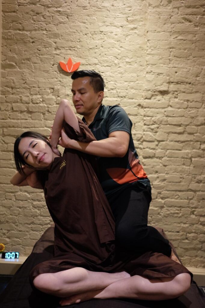 Thai Therapist performing assisted Thai stretching therapy for neck and shoulder tension at Asiatic Thai Massage Islington, London