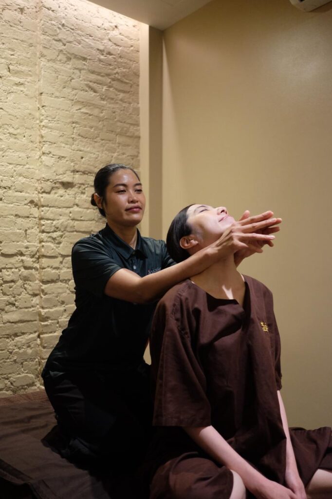 Therapist performing assisted neck stretch for muscle knot treatment and upper-body tension relief in London