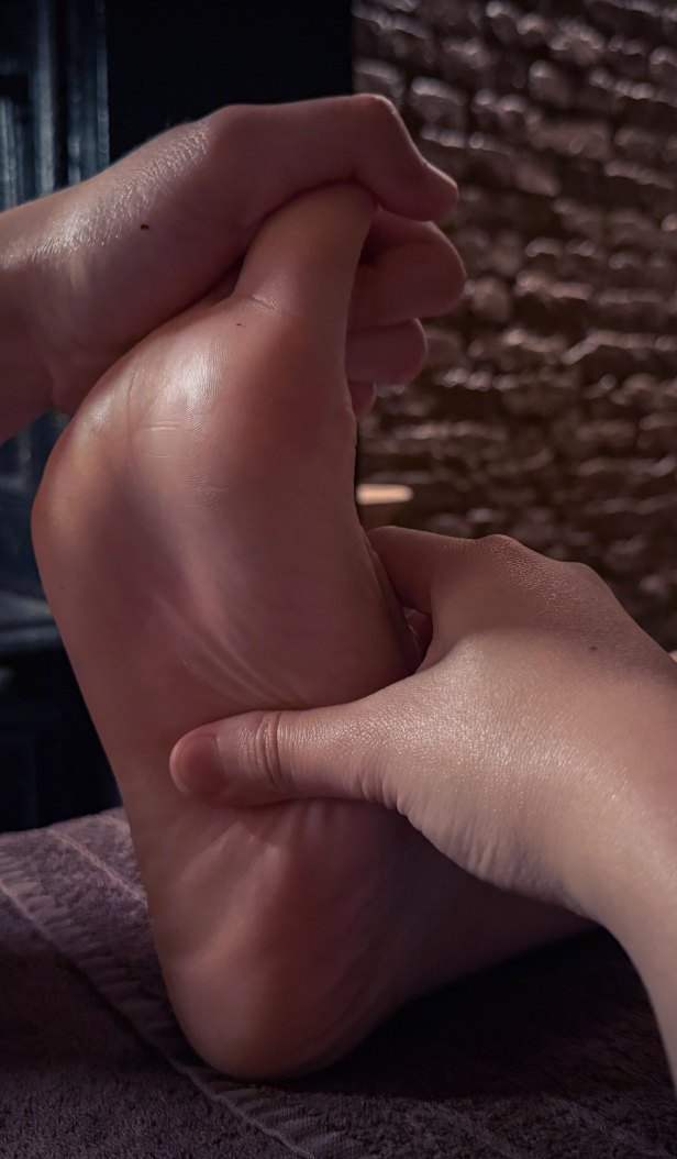 Hands massaging the sole of a foot