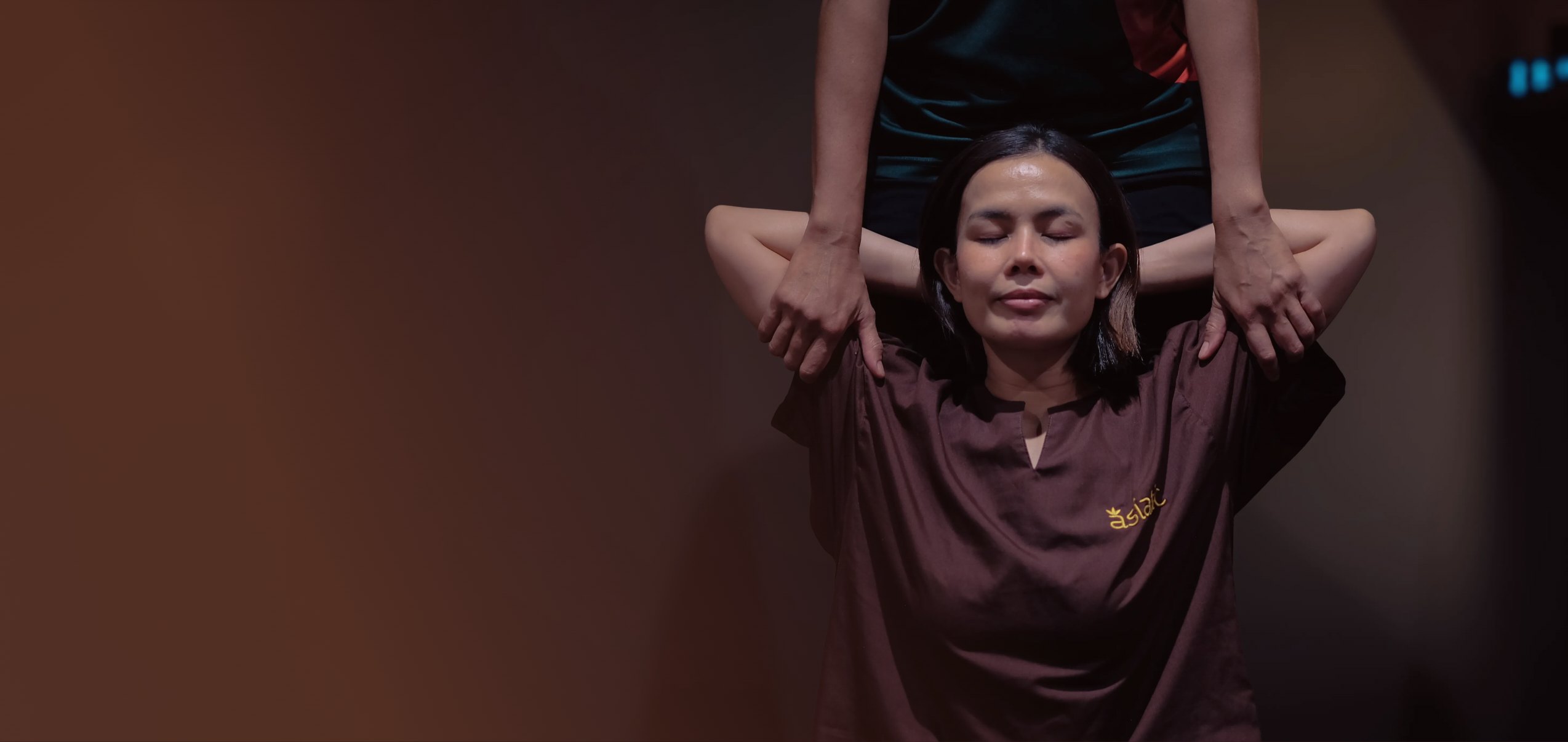 Therapist hands on a client's shoulders during a Thai massage